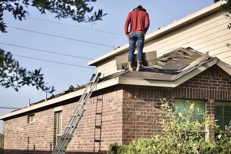Professional roofer working on a residential roof in Pequabuck
